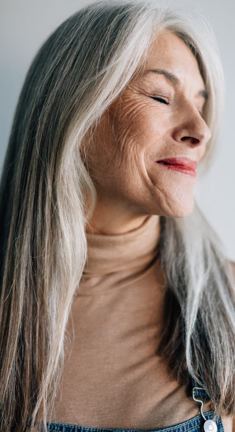 A woman with long gray hair, eyes closed, breathing calmly